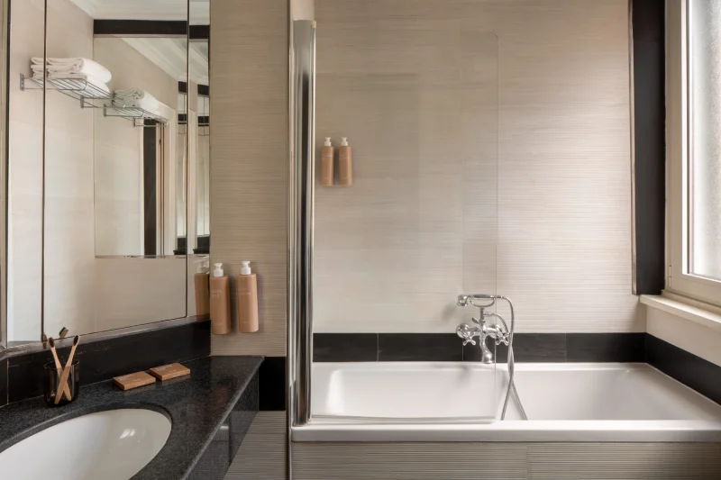 Bagno contemporaneo con vasca, lavabo nero e doccia in vetro vicino a Piazza della Repubblica - The Hotel Britannia, BZAR hotels a Roma