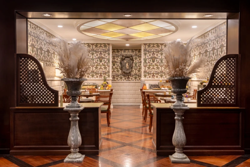 Ingresso sala colazione con vasi ornamentali, boiserie e pavimento geometrico a Roma - The Hotel Britannia, BZAR hotels a Roma