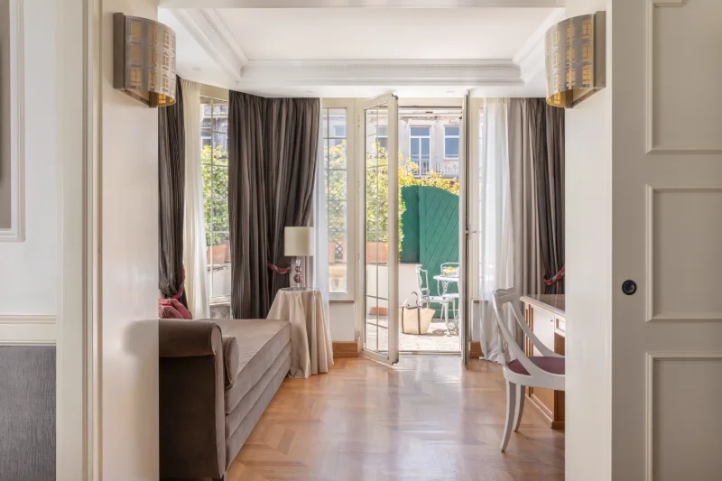 Dettaglio suite con letto, testiera a righe, tende eleganti e TV vicino al Teatro dell'Opera - The Hotel Britannia, BZAR hotels a Roma